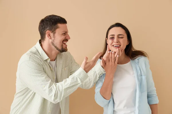 Angry Husband His Bruised Wife Beige Background Domestic Violence Concept — Stock Photo, Image