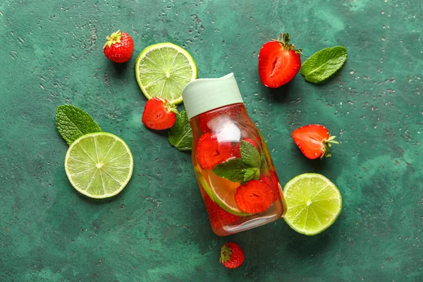 stock image Bottle of infused water with strawberry and lime on green background