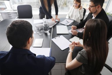 Ofiste iş planı üzerinde çalışan bir grup insan.