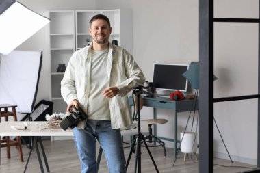 Stüdyoda profesyonel kamerası olan yakışıklı bir fotoğrafçı.