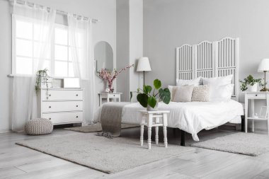 Açık renk yatak odasının içinde, çekmecelerde modern dizüstü bilgisayarlar var.