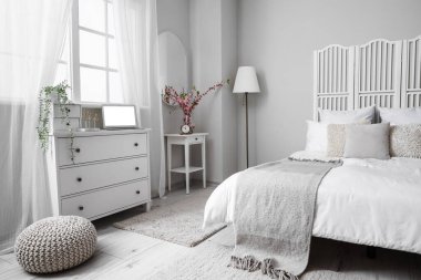 Açık renk yatak odasının içinde, çekmecelerde modern dizüstü bilgisayarlar var.