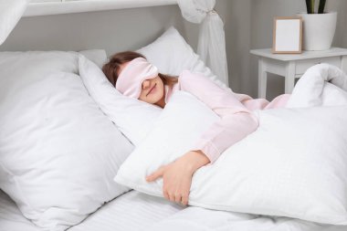 Güzel genç bir kadının yumuşak yatakta uyuduğu bir sabah.