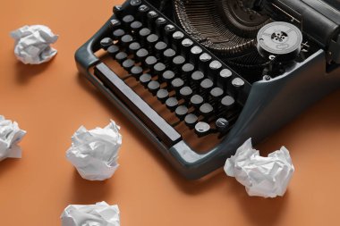 Turuncu arka planda buruşuk kağıtlı klasik daktilo