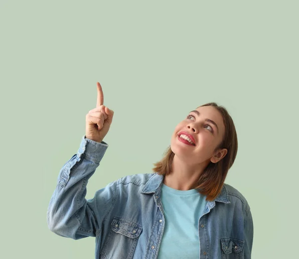 Young Woman Denim Shirt Pointing Something Green Background — Stock Photo, Image