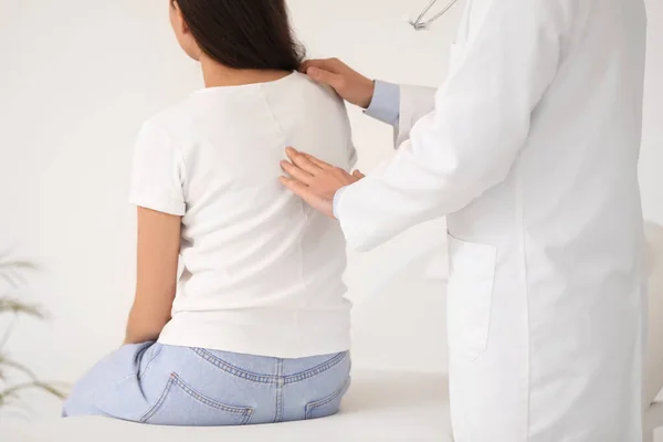 男医生检查年轻妇女在诊所的体位 — 图库照片