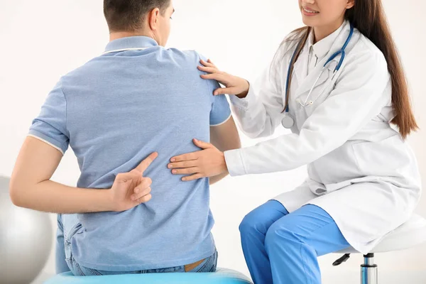 Doctora Comprobando Postura Del Joven Clínica —  Fotos de Stock