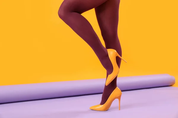 Γυναικεία Πόδια Μαύρο Καλσόν Και Κίτρινα Ψηλά Τακούνια Στο Φόντο — Φωτογραφία Αρχείου