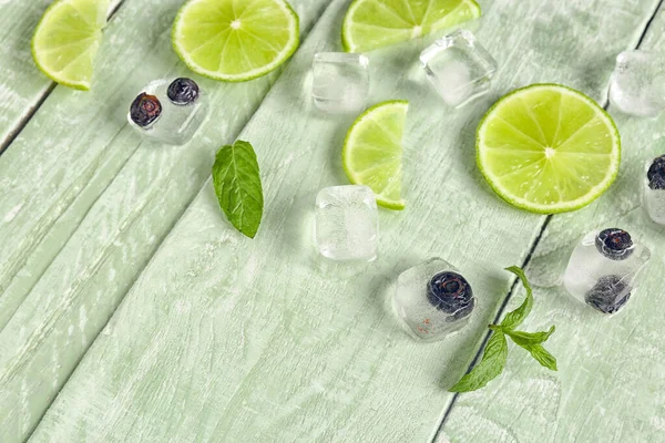 Slices Fresh Lime Blueberry Frozen Ice Cubes Green Wooden Background — Stock Photo, Image
