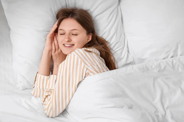 美しい若い女性の朝柔らかいベッドで寝て トップビュー — ストック写真