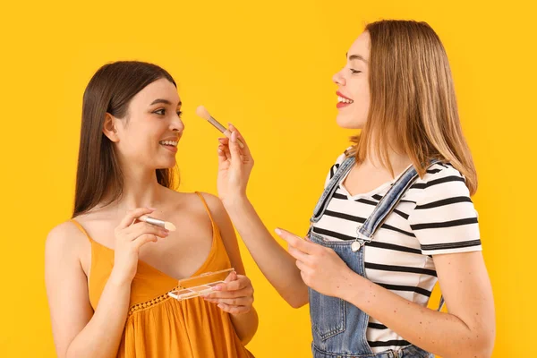 Amigos Sexo Feminino Fazendo Maquiagem Fundo Amarelo — Fotografia de Stock