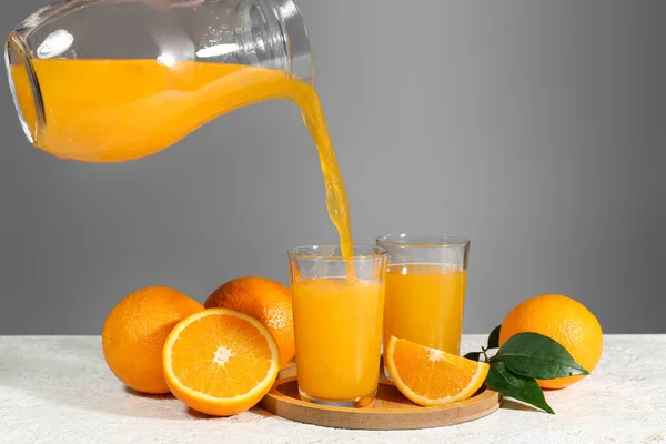 Pouring Fresh Orange Juice Jug Glasses Table Grey Background — Stock Photo, Image