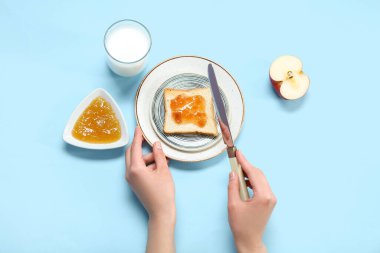 Lezzetli tost, reçel ve sütle renklendirilmiş kadın elleri