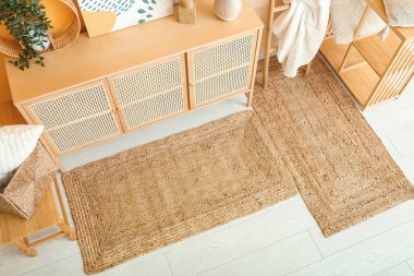 Çekmeceleri, rafları ve hasır halıları olan şık bir oturma odası.