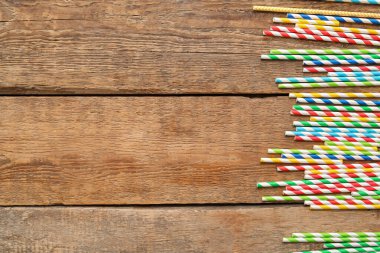 Farklı kâğıtlar ahşap arka planda pipet içiyor.