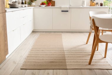 Modern mutfağın içinde şık bej halı.