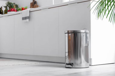 Modern mutfağın içindeki metal çöp tenekesi.