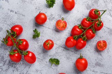 Taze vişneli domates ve gri arka planda maydanoz.