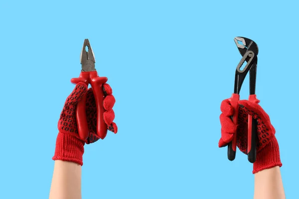 Vrouwelijke Handen Rode Handschoenen Met Verschillende Tangen Blauwe Achtergrond — Stockfoto