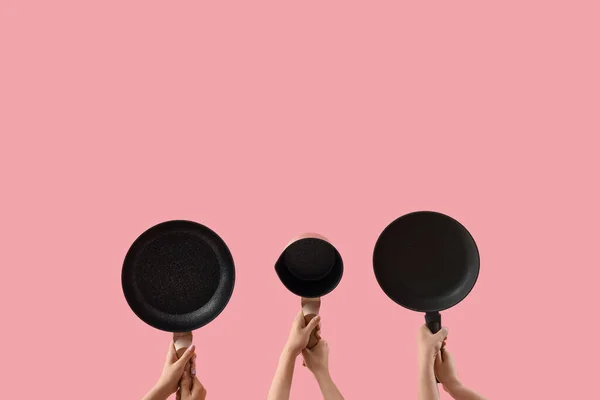 Female Hands Holding Different Frying Pans Pink Background — Stock Photo, Image