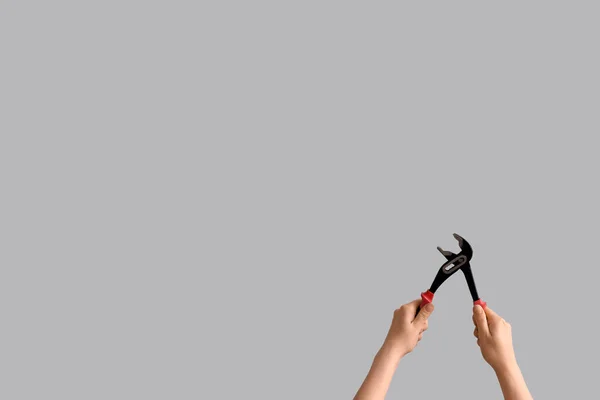 Mains Féminines Tenant Une Pince Pompe Eau Sur Fond Gris — Photo