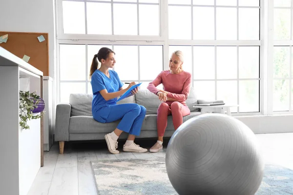 Vrouwelijke Fysiotherapeut Met Klembord Volwassen Vrouw Revalidatiecentrum — Stockfoto