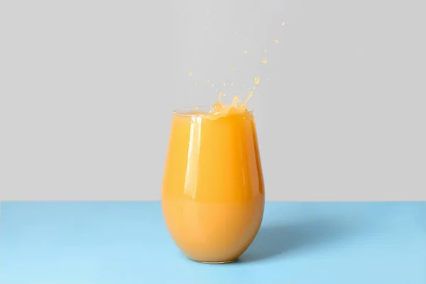 Glas Frischer Orangensaft Mit Spritzern Auf Dem Tisch Vor Grauem — Stockfoto