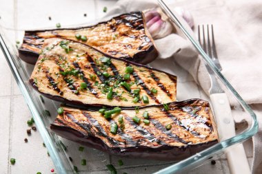 Hafif arka planda leziz ızgara patlıcanlı cam güveç, yakın plan.