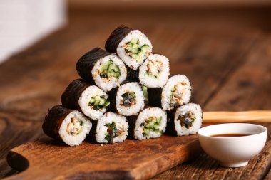 Lezzetli maki ruloları ahşap masada.