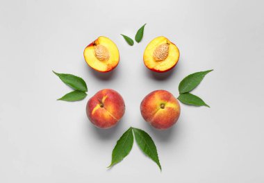 Gri arkaplanda tatlı şeftaliler ve yapraklar