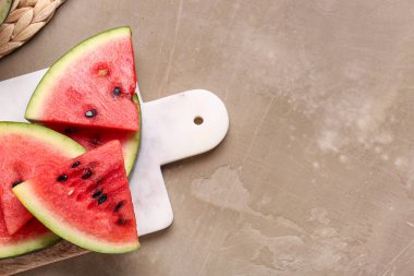 Kahverengi zemin üzerinde taze karpuz parçaları olan tahta.