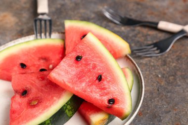 Koyu arkaplanda taze karpuz parçaları var.