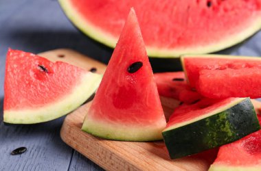 Mavi ahşap arka planda taze karpuz parçaları olan tahta.