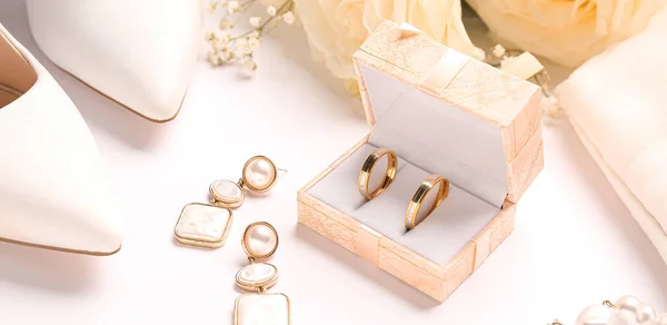 有结婚戒指 耳环和白底女鞋的盒子 — 图库照片