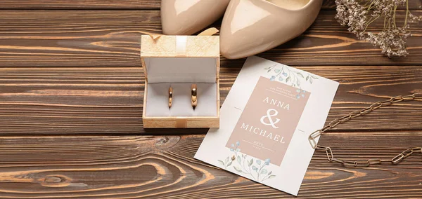 木製の背景に結婚指輪 招待状と女性の靴付きのボックス — ストック写真