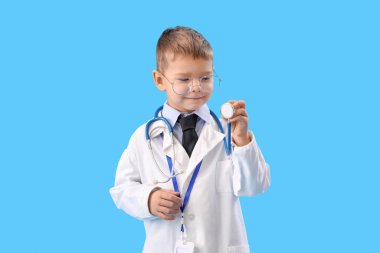 Cute little doctor with stethoscope on blue background