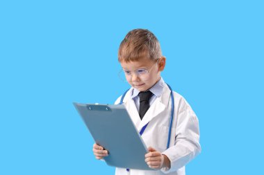 Mavi arka planda panosu olan sevimli küçük bir doktor.