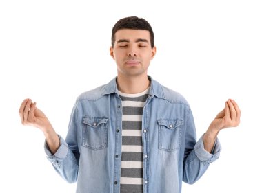 Genç adam beyaz arka plan üzerinde meditasyon yapıyor. Denge kavramı