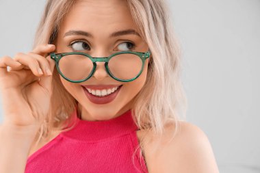 Hafif arka planda şık gözlüklü genç bayan, yakın plan.