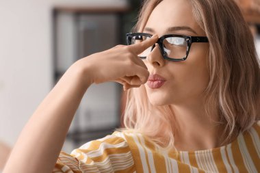 Ofiste şık gözlükleri olan genç bir kadın, yakın plan.