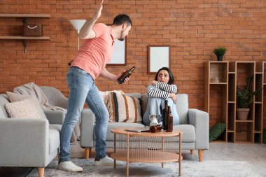 Evde sarhoş kocasıyla korkmuş genç bir kadın. Aile içi şiddet kavramı