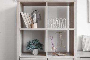 Parlayan lamba, kitaplar ve ışık duvarının yanında dekor olan raf ünitesi.