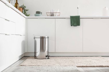 Modern mutfağın içindeki metal çöp tenekesi.