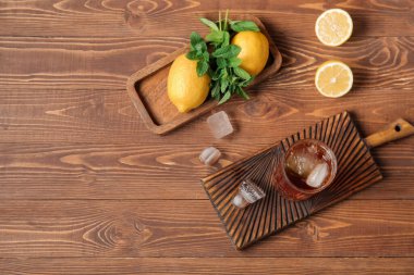 Tahta zemin üzerinde buzlu çay ve limon dolu tahtalar.