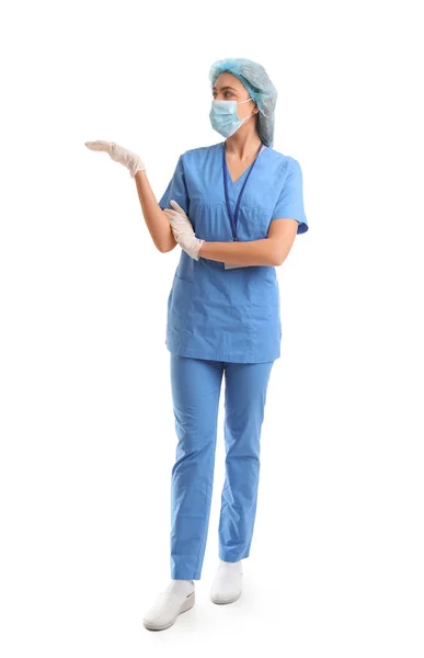 白い背景に何かを示す医療マスクの女性看護師 — ストック写真