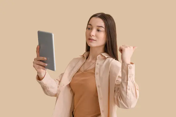 Mladá Žena Tabletovým Počítačem Ukazuje Něco Béžového Pozadí — Stock fotografie