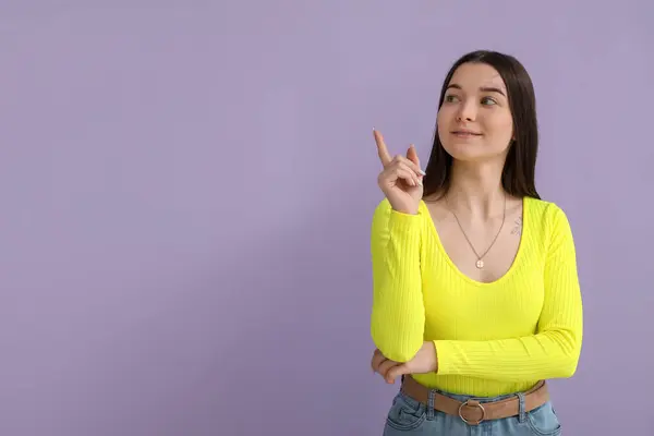 Young Woman Bright Shirt Pointing Something Lilac Background — Stock Photo, Image