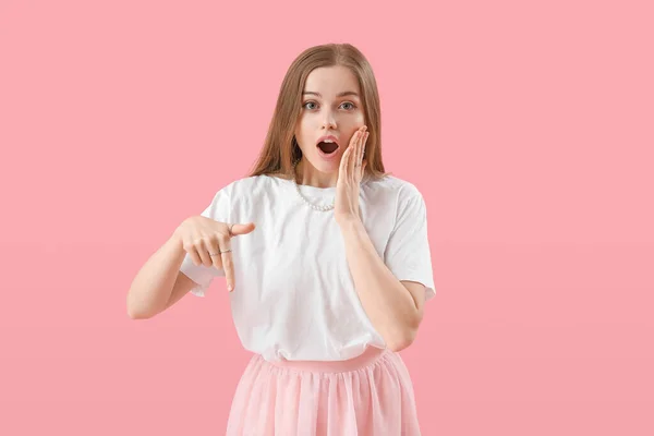 Σοκαρισμένη Νεαρή Γυναίκα Δείχνει Κάτι Ροζ Φόντο — Φωτογραφία Αρχείου