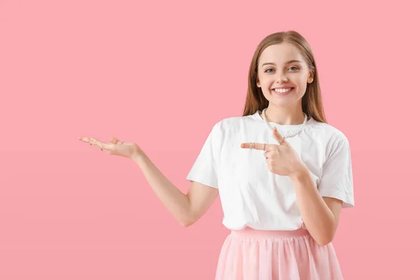 Jonge Vrouw Shirt Wijzend Naar Iets Roze Achtergrond — Stockfoto