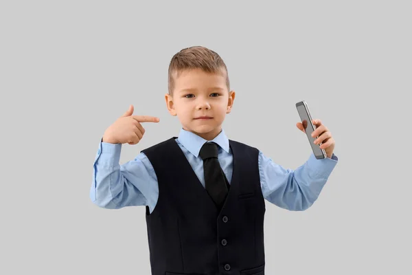 Lindo Pequeño Hombre Negocios Apuntando Teléfono Móvil Sobre Fondo Gris — Foto de Stock